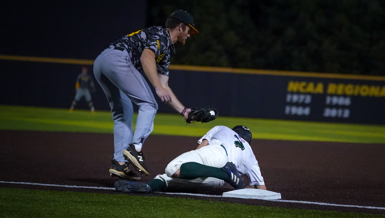 Tyson Bass slides into third base vs. the Owls